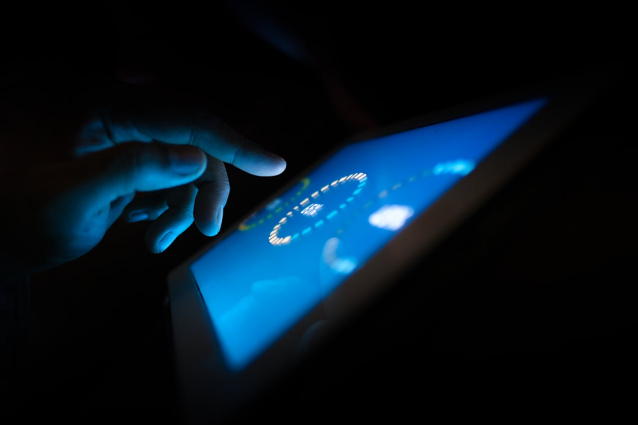 hero-img Close-up of a hand interacting with a glowing touchscreen in a dark setting, highlighting technology use.